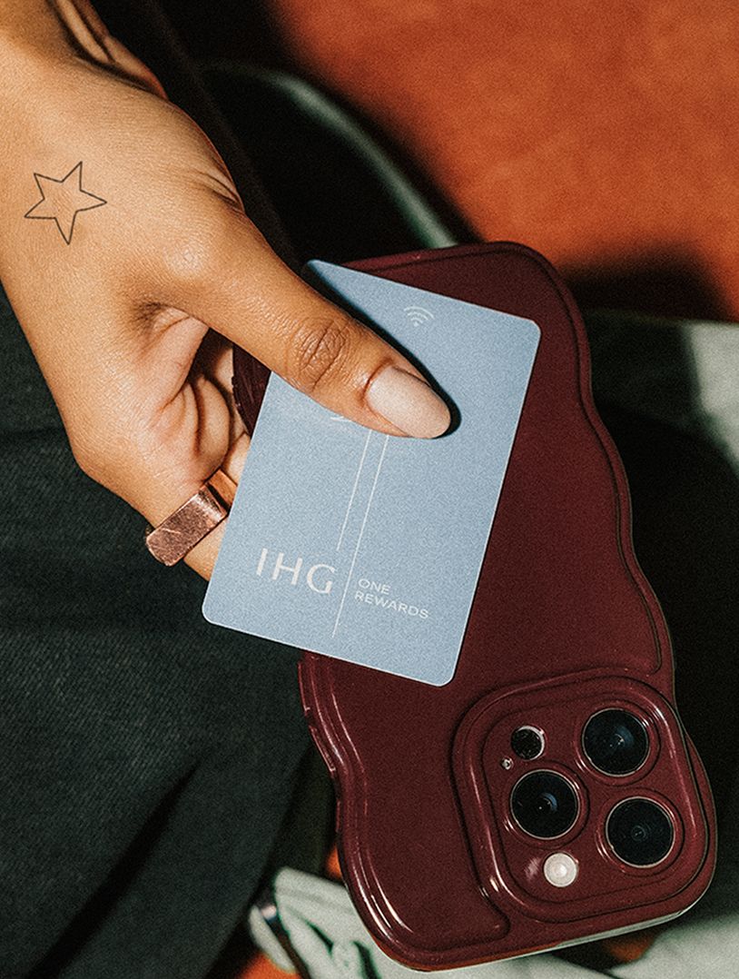 hand with tiny tattoo holding ihg key card