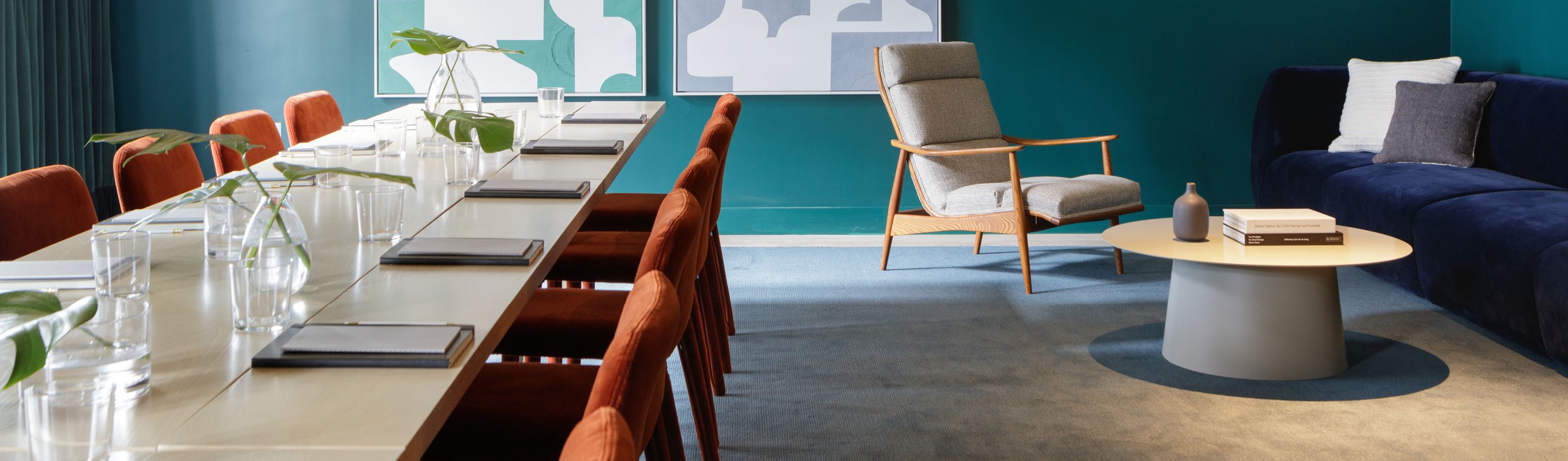 large meeting room with plush seating and pellegrino water bottles