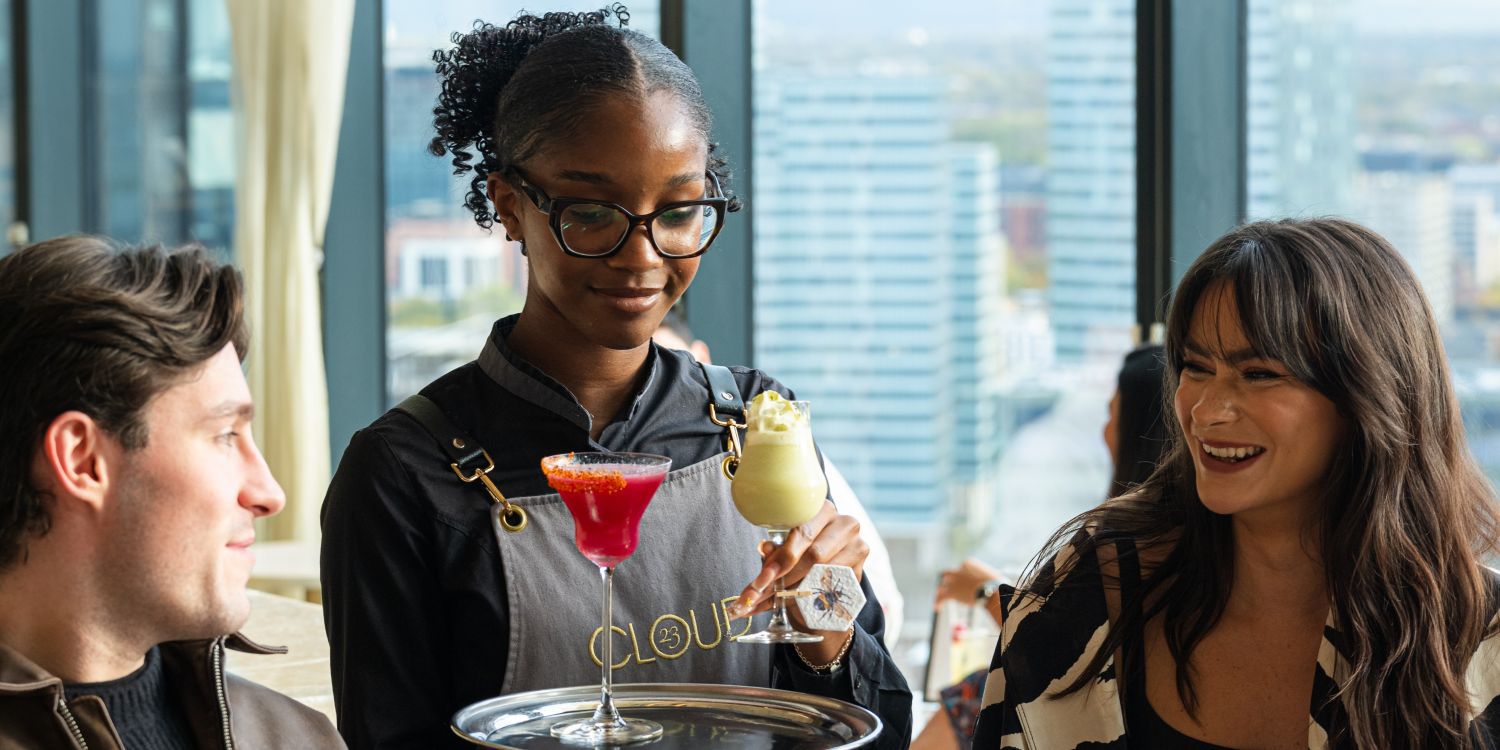 couple being served cocktails at bar