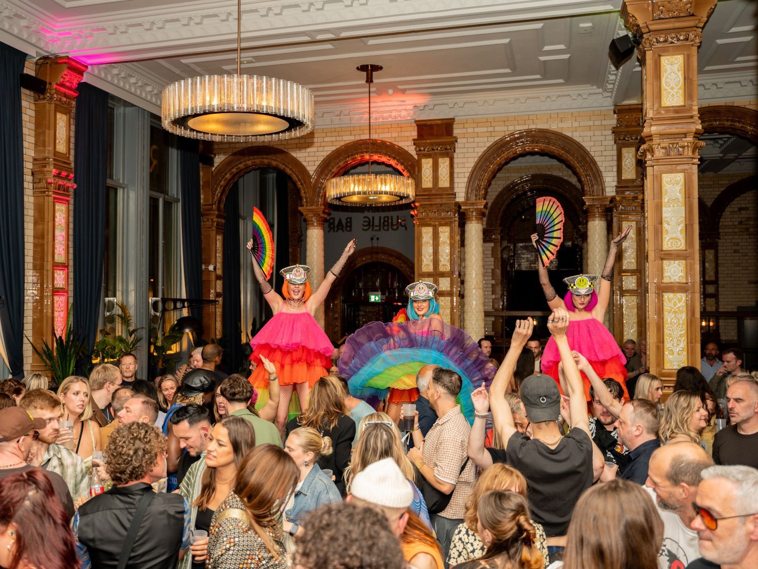 Large event area filled with people drinking and dancing 