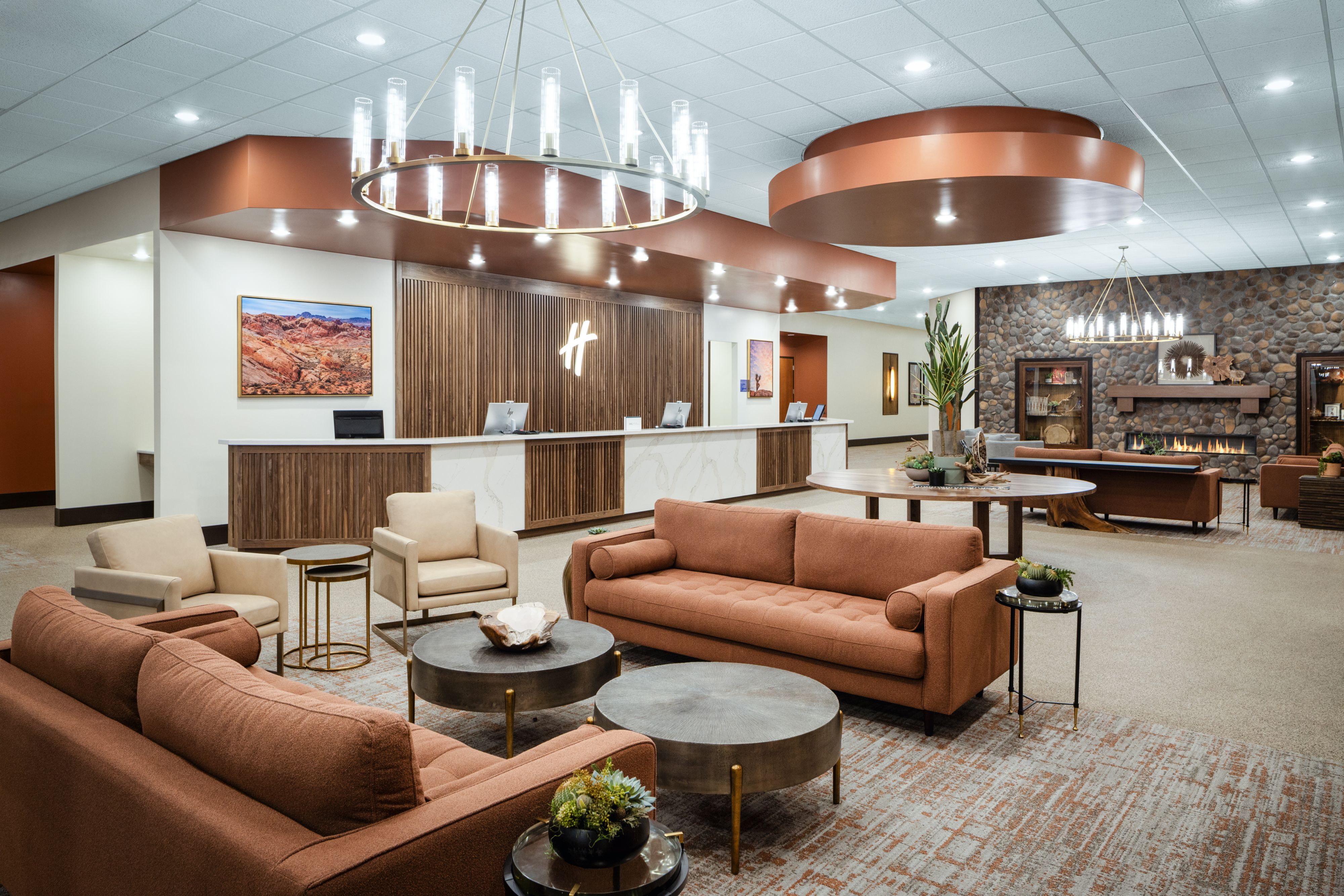 Warm indoor seating area with couches and hanging light fixtures.