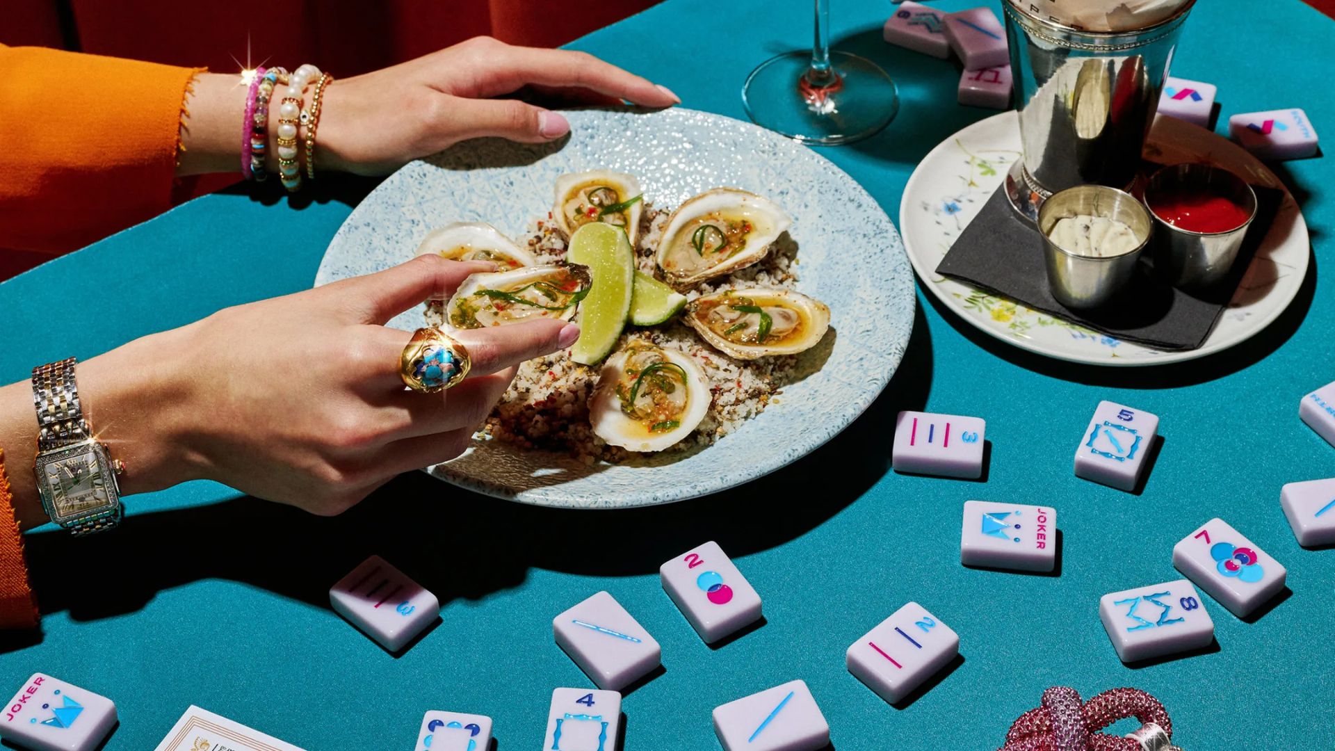 Mahjong tiles are scattered across the teal-colored table