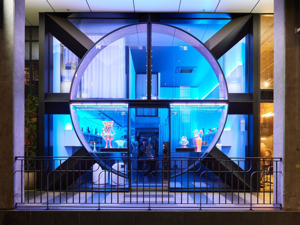 Blue-lit storefront with circular glass display windows.