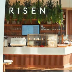 Modern café counter with plants and Risen signage