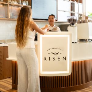 Woman ordering at Risen café counter with staff member
