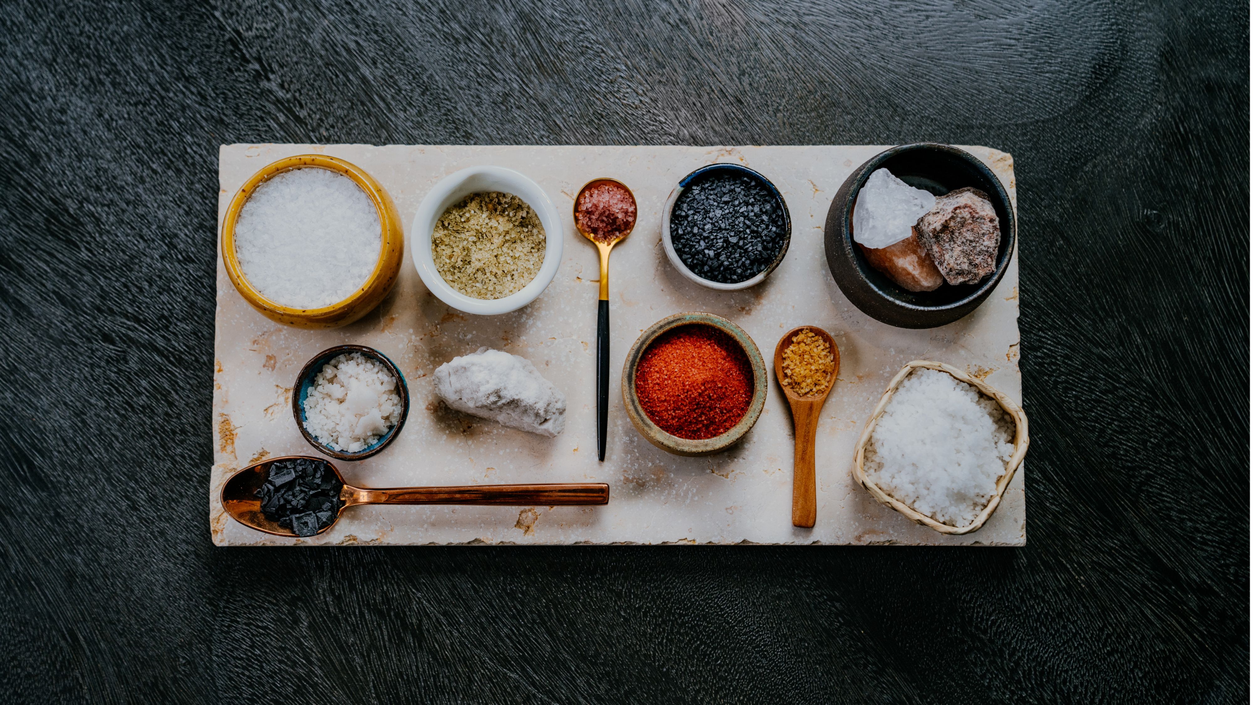 overhead view of a platter with 10 types of salt displayed