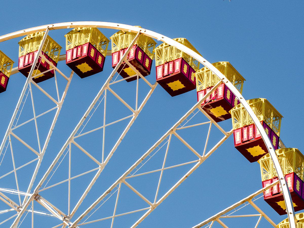 Ferris wheel cabins against a clear blue sky.