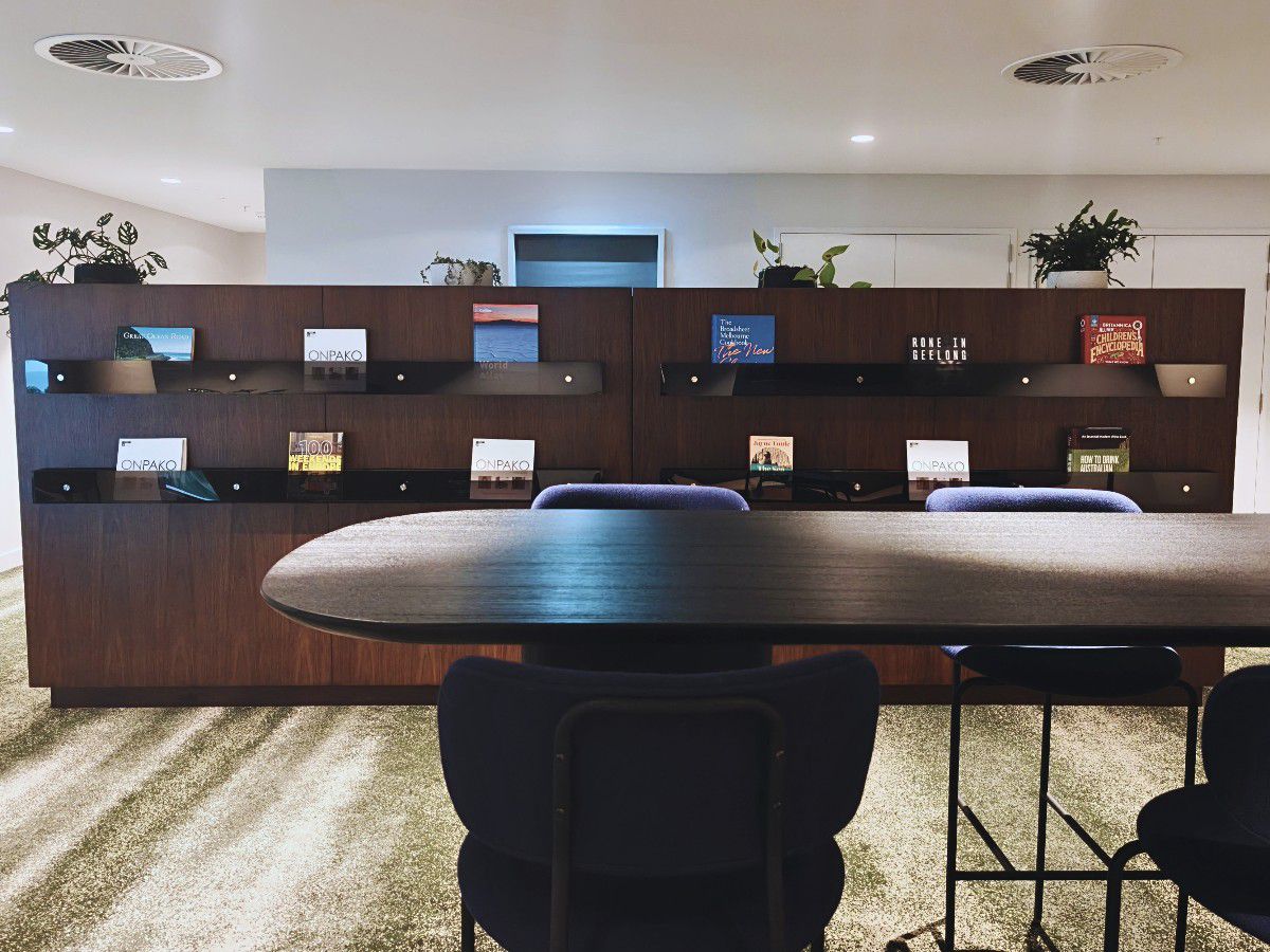 Modern social lounge with bar seating and shelving.