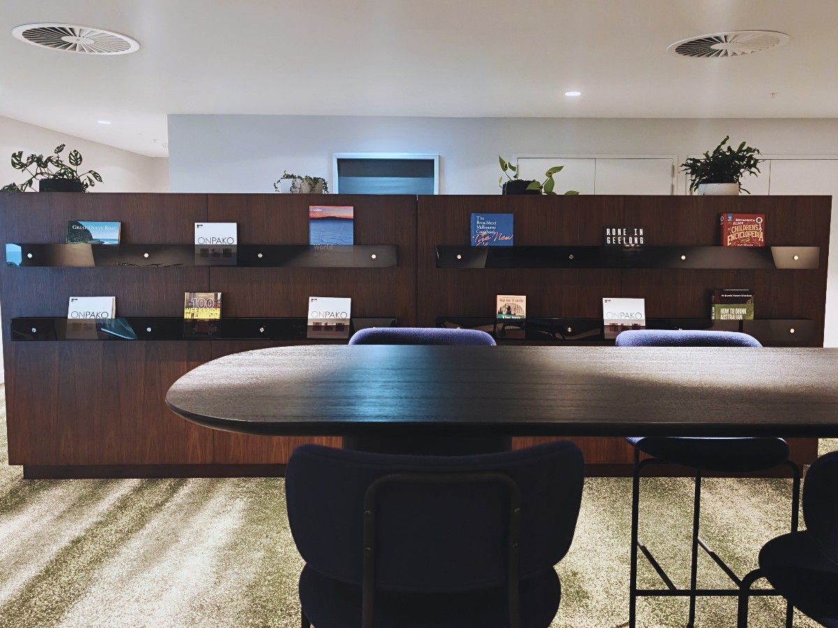 Modern social space with seating and shelving.