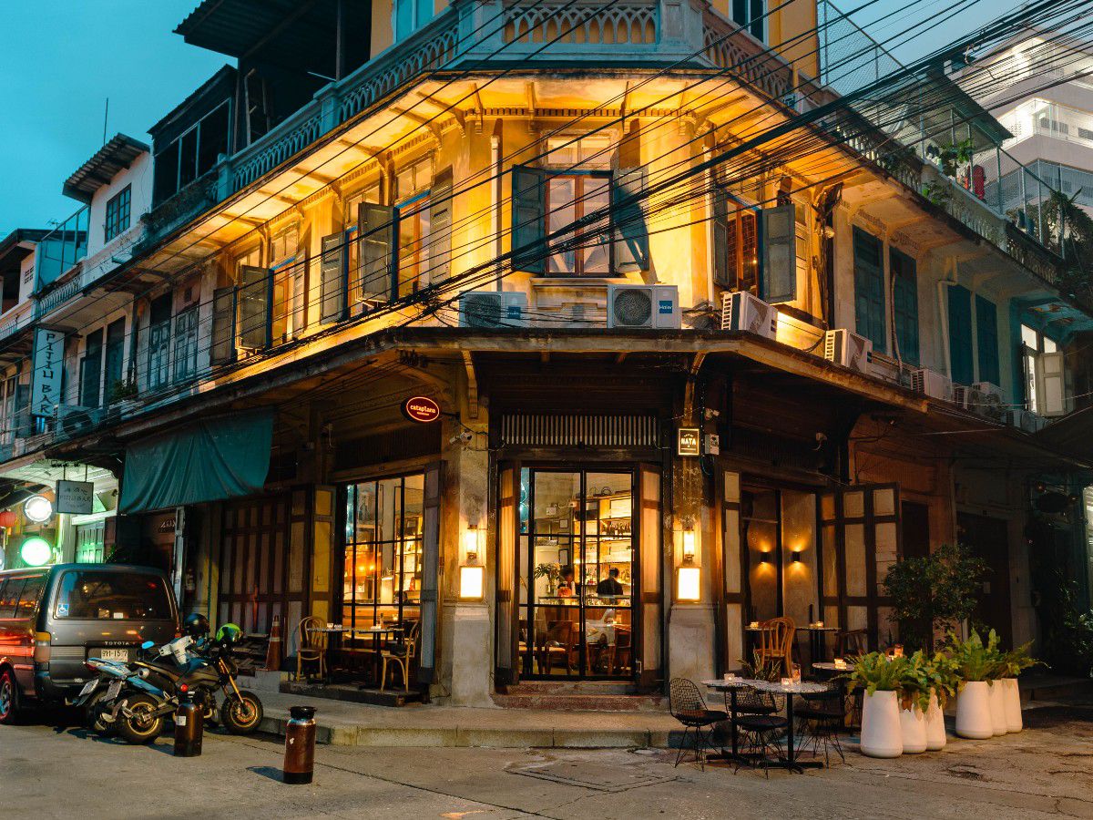 Charming street-side café in a historic building illuminated at dusk.