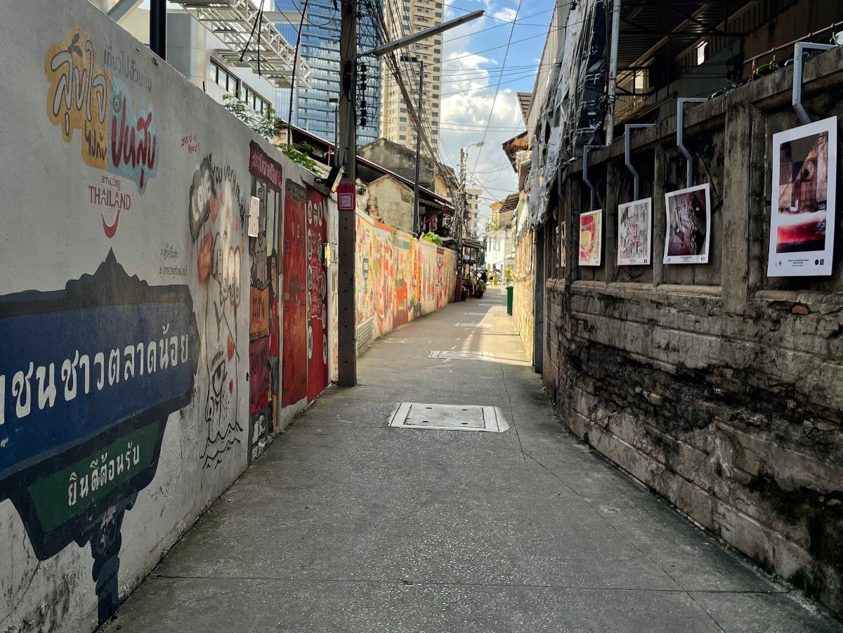 Urban alleyway lined with colorful street art and local character.