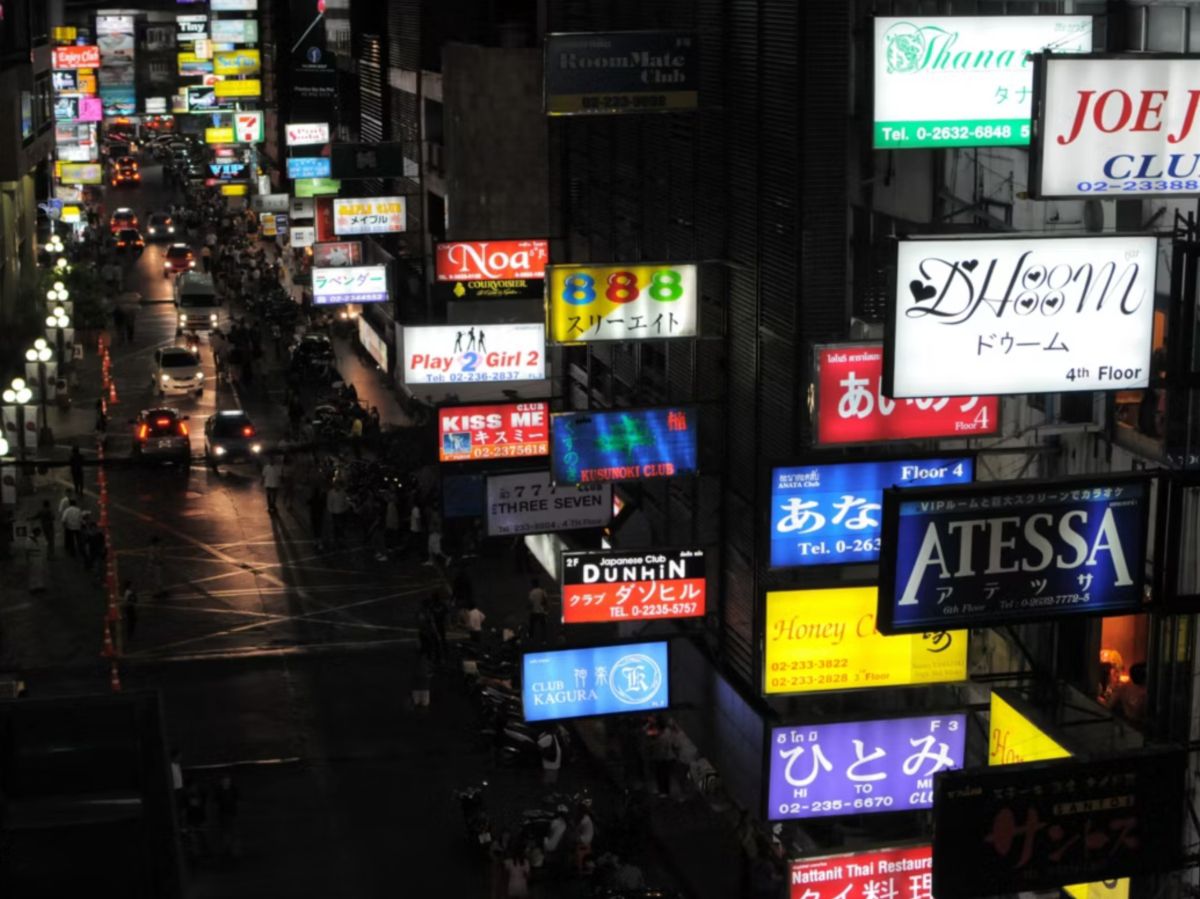 Neon-lit city street with vibrant nightlife and illuminated signs.