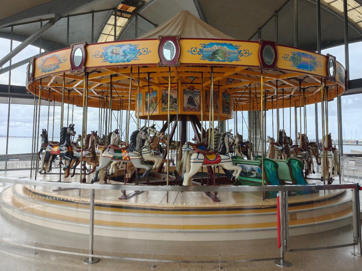Colorful carousel with horses indoors.