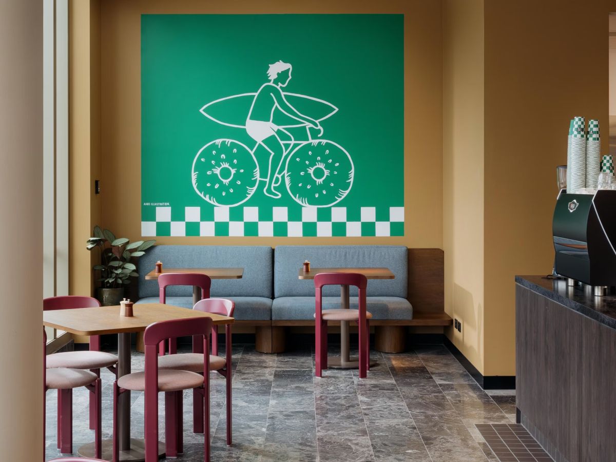 Café seating area with colorful wall artwork.