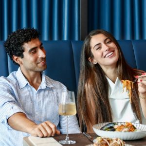 Couple enjoying dinner together with wine and pasta