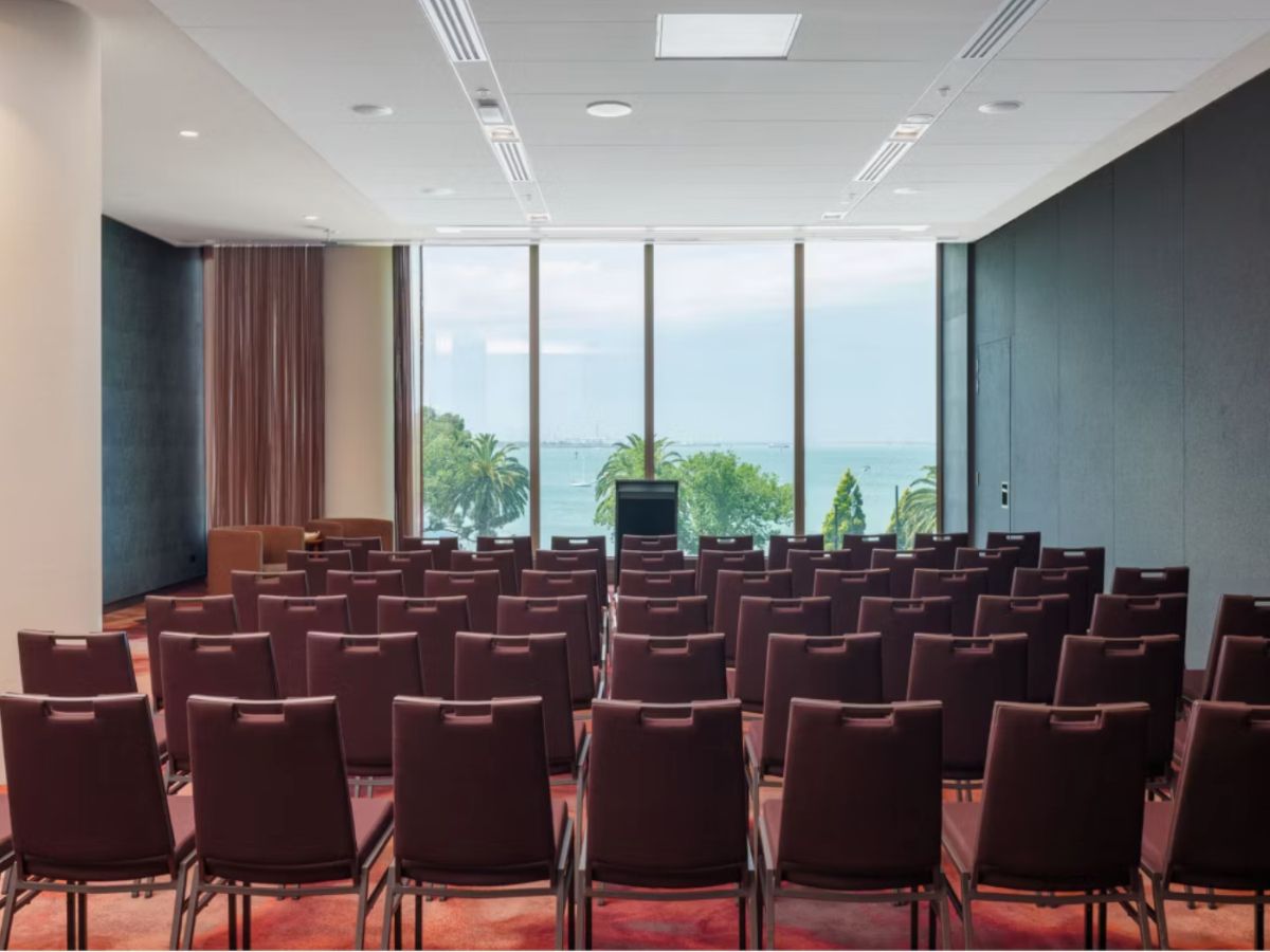Modern waterfront conference room with rows of seating.