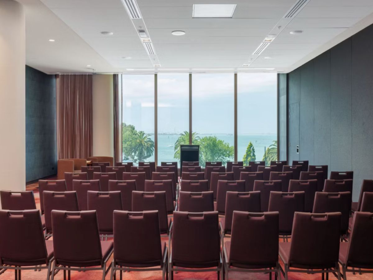 Conference room with rows of chairs and ocean views.