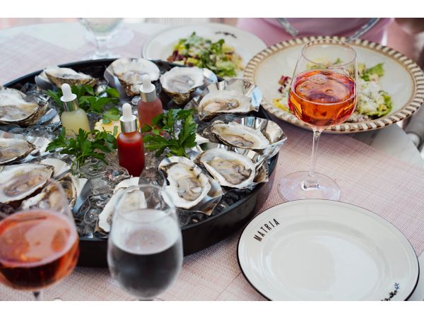 Guests enjoying small plates of sharable bites at Matria 