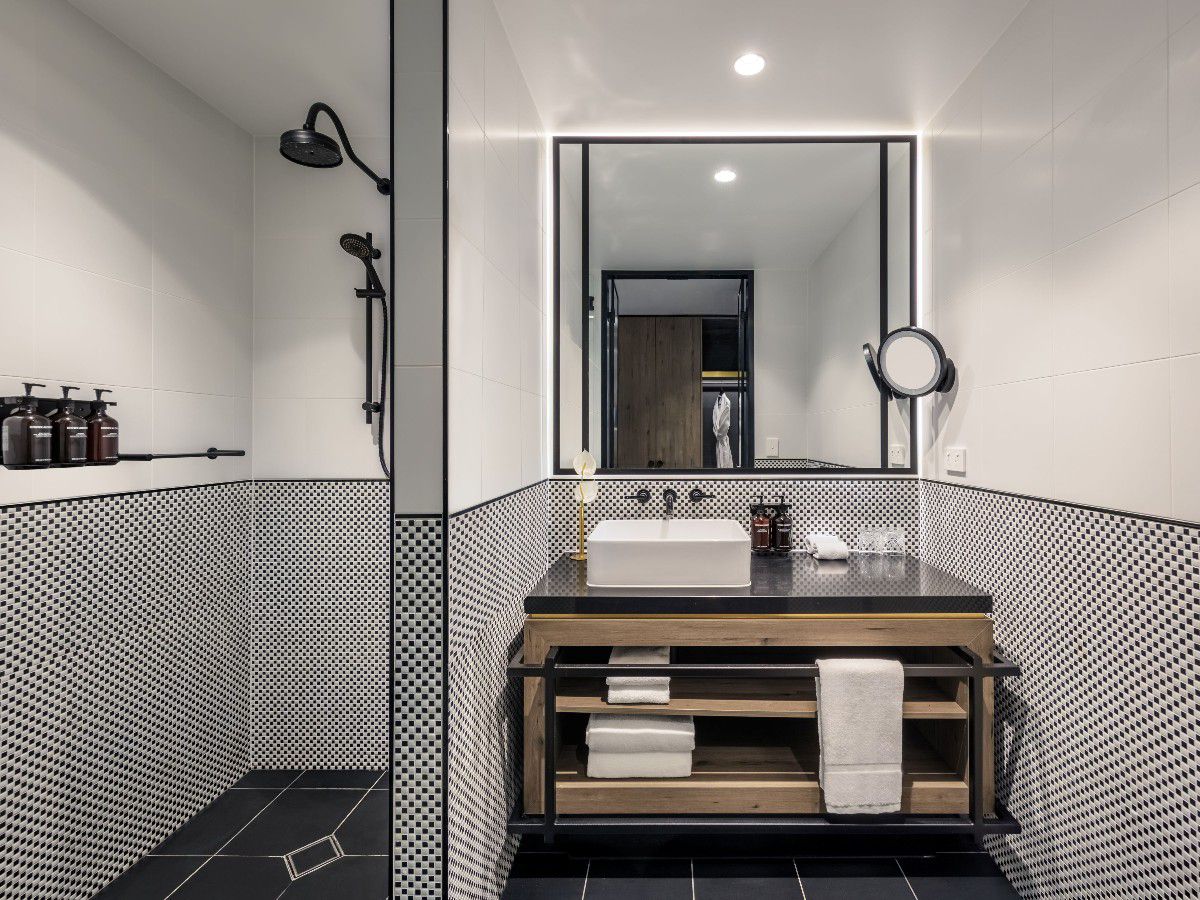 Modern bathroom with vanity, mirror, and shower.