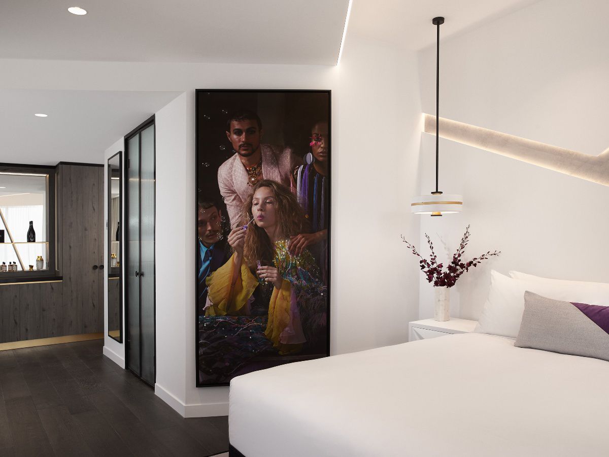 Modern hotel bedroom with city view through windows