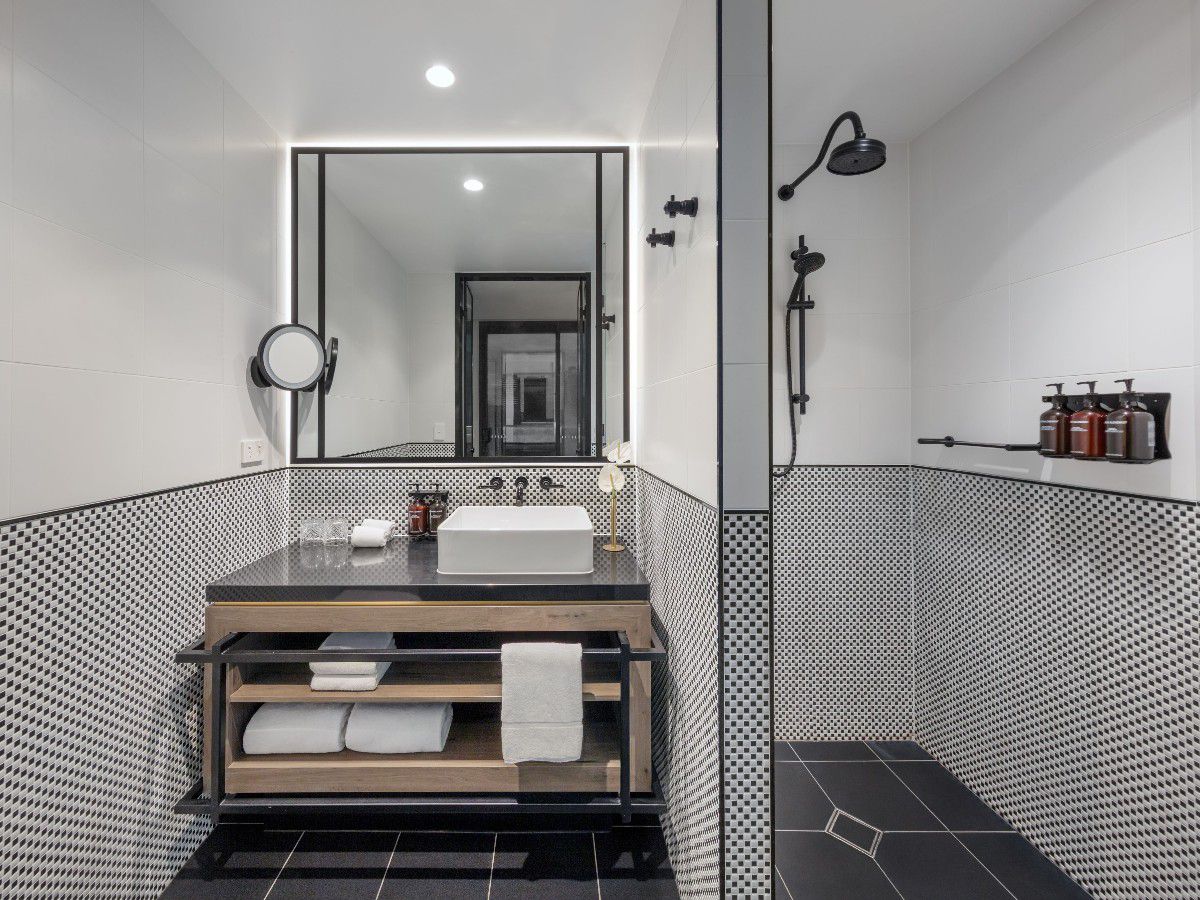 Modern bathroom with vanity, mirror, and shower.