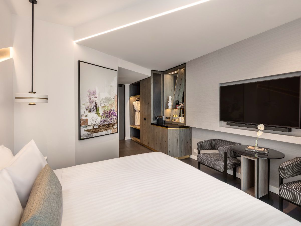 Modern hotel bedroom with city view through windows