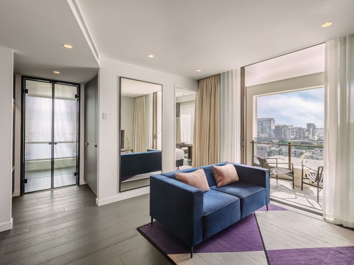 Modern hotel bedroom with city view through windows