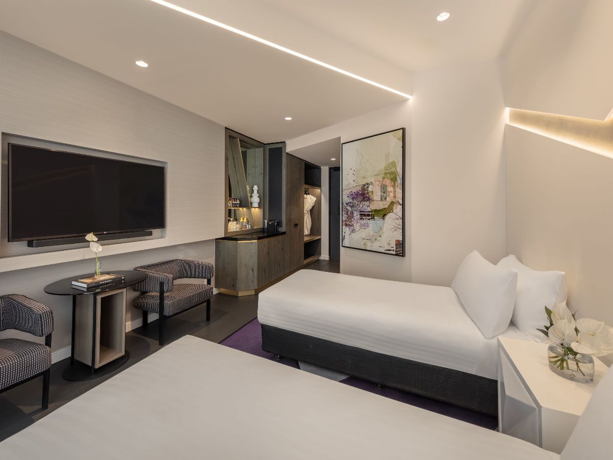 Modern twin hotel room with two beds and seating