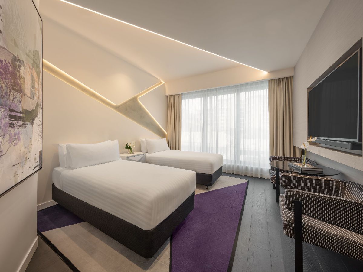 Modern twin hotel room with two beds and seating