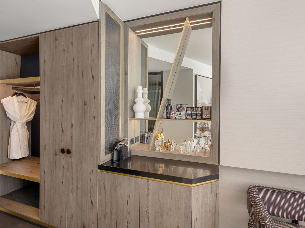 Modern hotel bedroom with city view through windows
