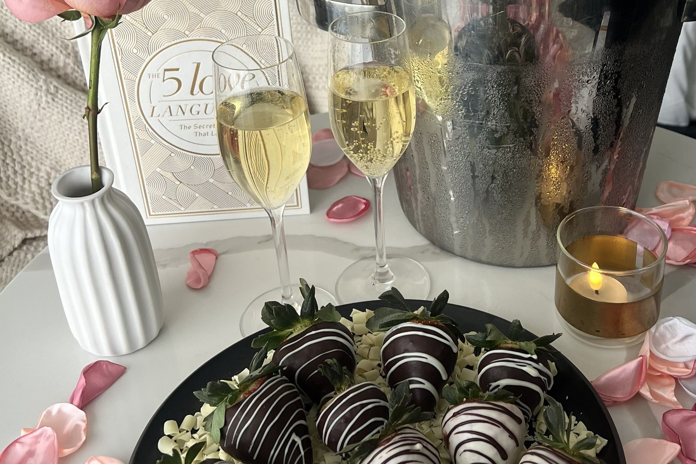 Chocolate-covered strawberries with champagne and rose petals