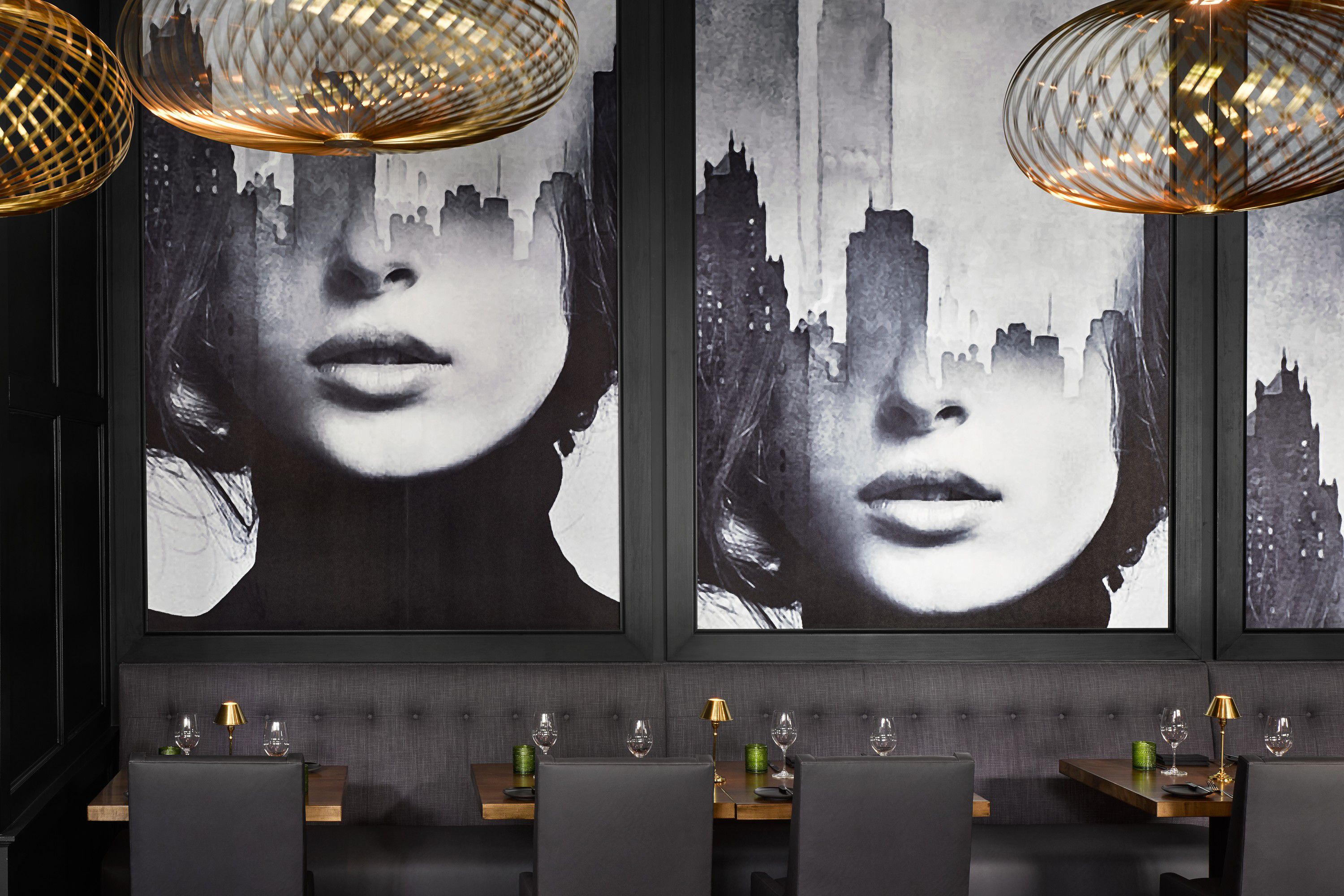 black and white mural of two women on wall with gold fixtures