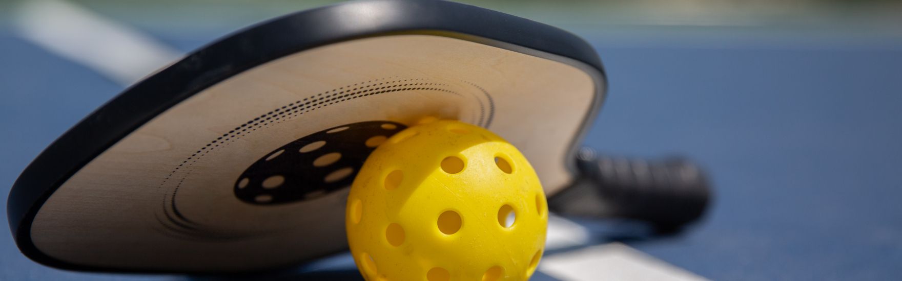Pickeball paddle and ball on court