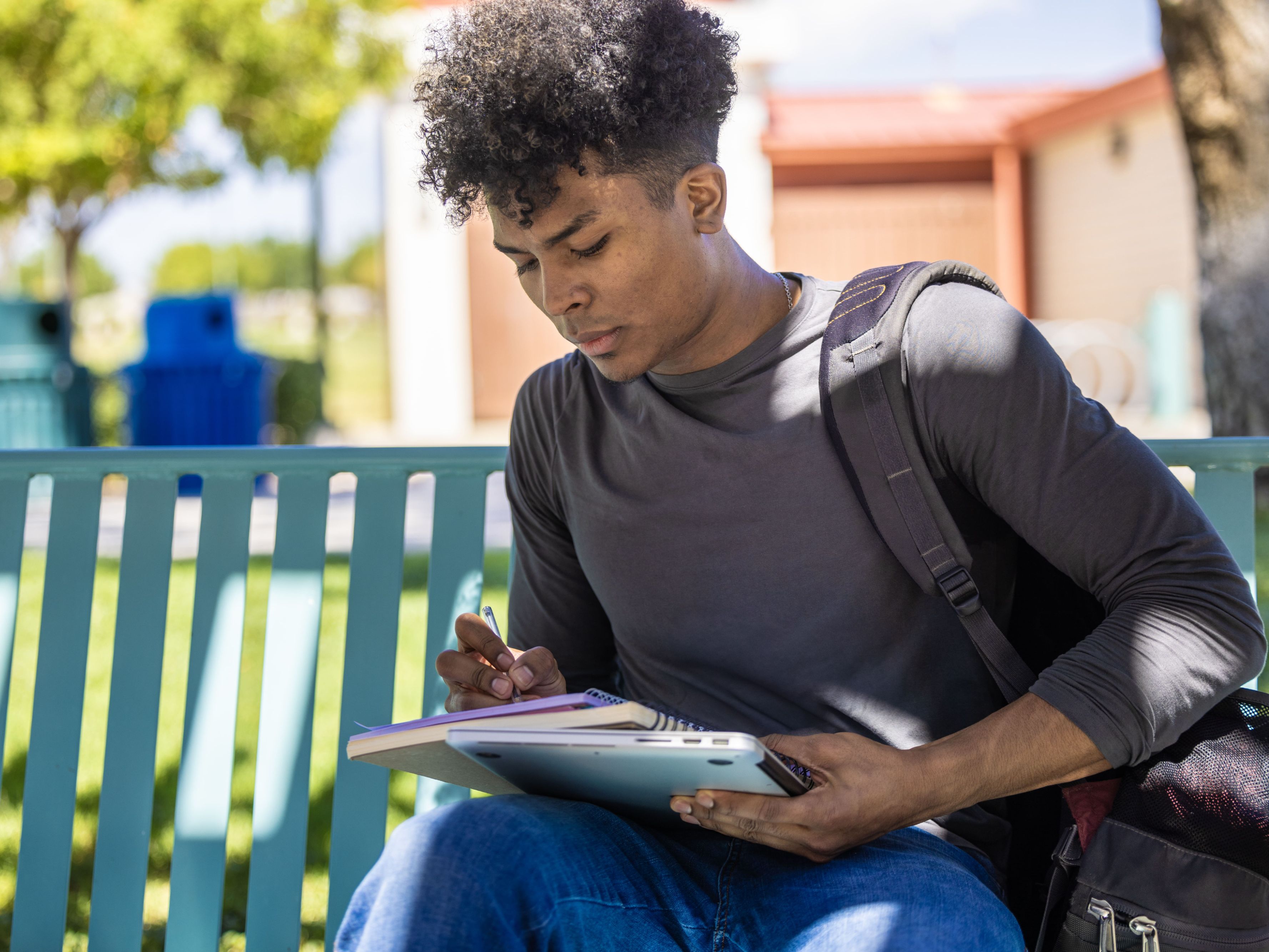student working on a bench on campus