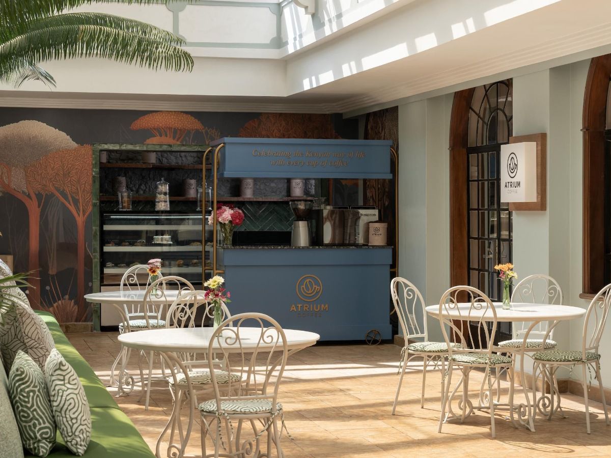 Sunlit atrium café with elegant seating and coffee kiosk