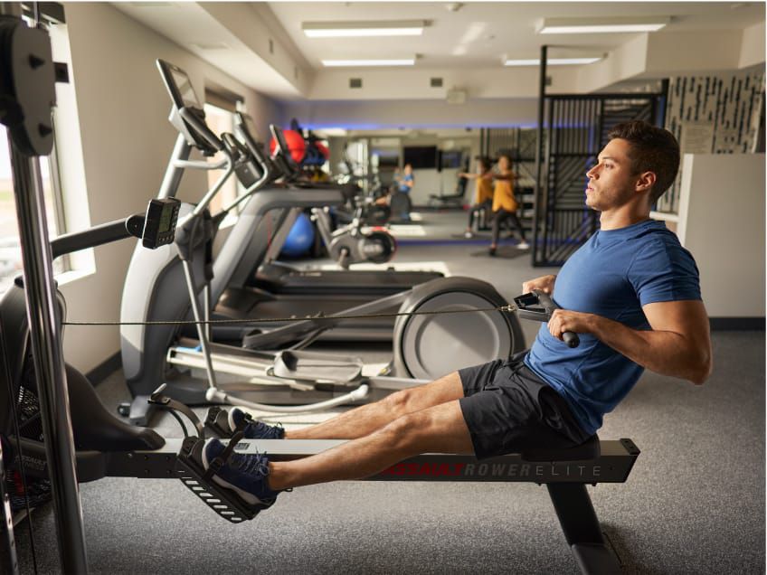 Well-lit fitness studio with towels, treadmills, an exercise bike and other equipment.