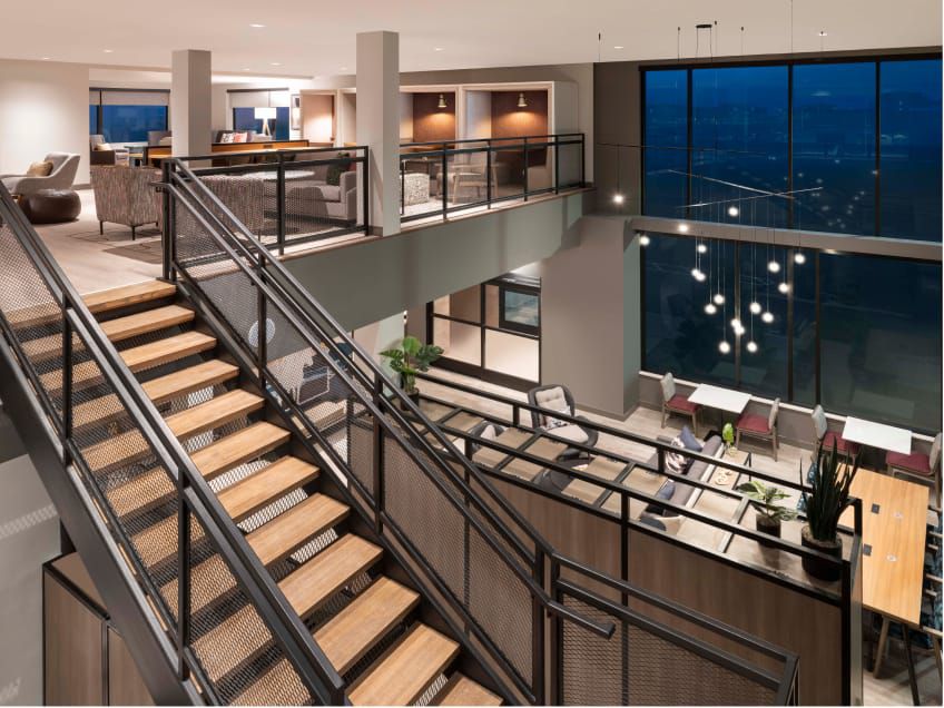 Two-story lobby with coworking tables and booths upstairs.