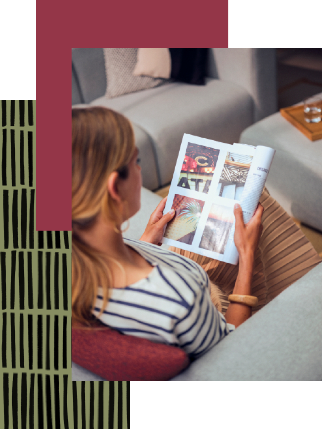 A woman wearing a striped shirt and a cool, chunky bracelet reads a magazine while relaxing on her hotel room couch.