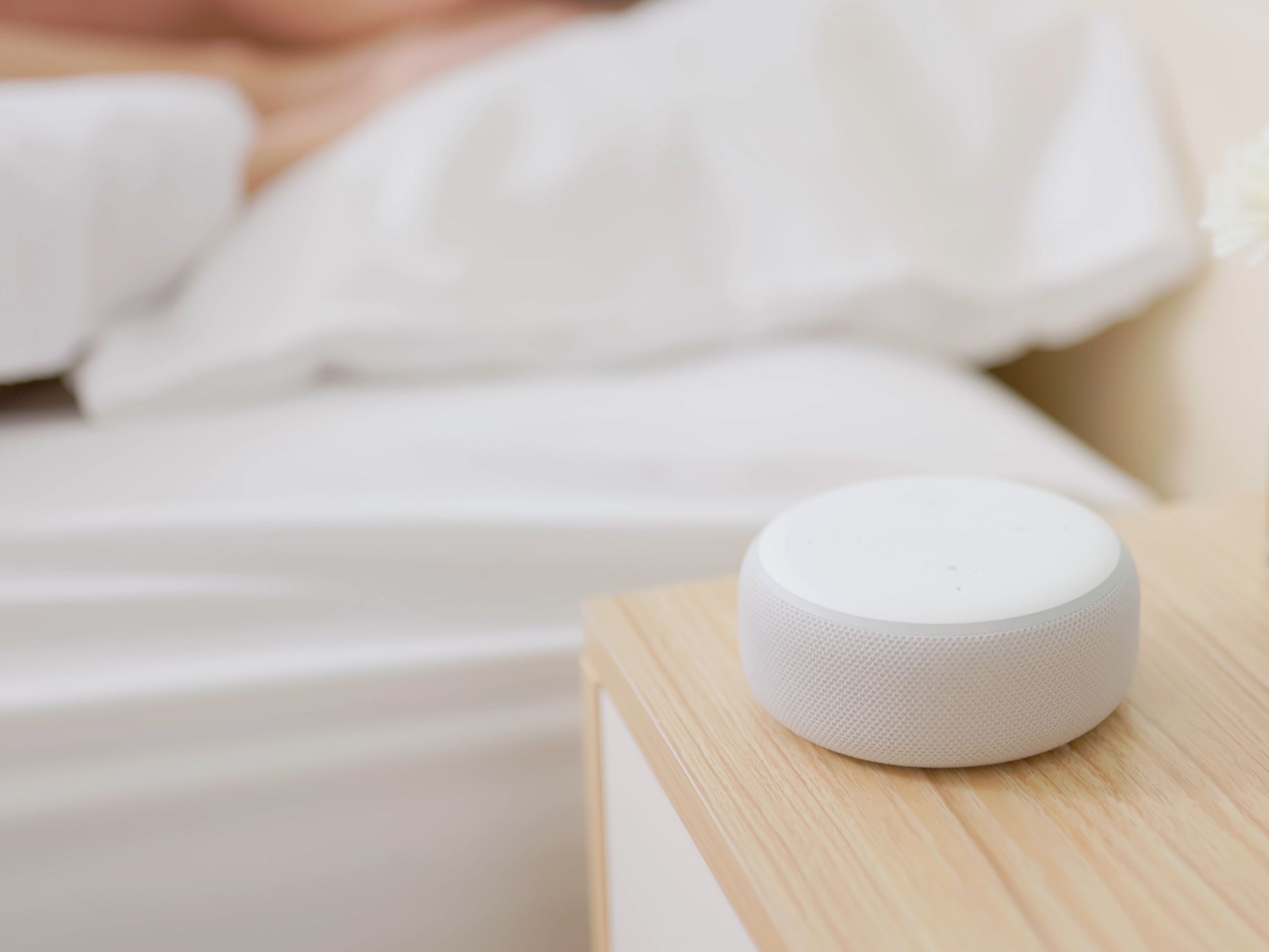 Woman sleeping with a sound machine beside her.