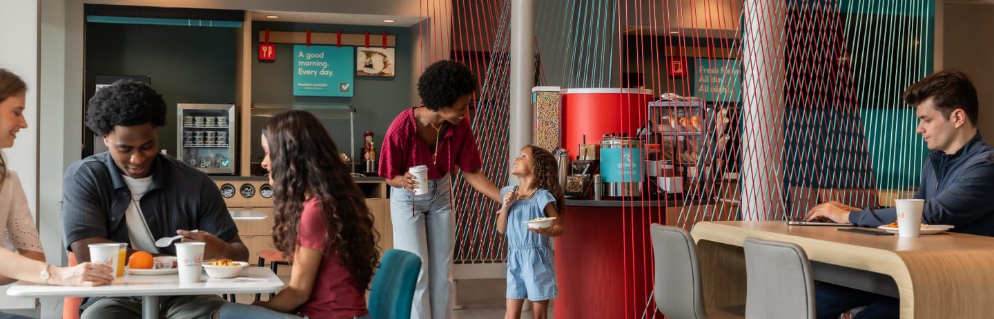 Breakfast area of hotel with people gathered enjoying the offerings