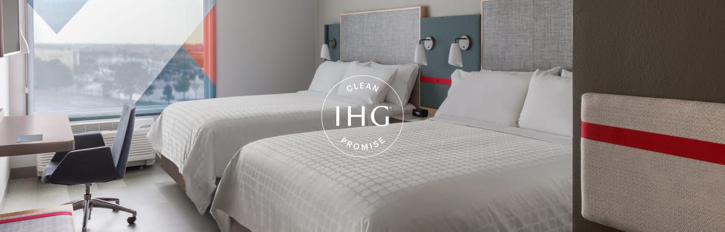 IHG Clean Promise logo overlaid on image of clean, modern hotel room