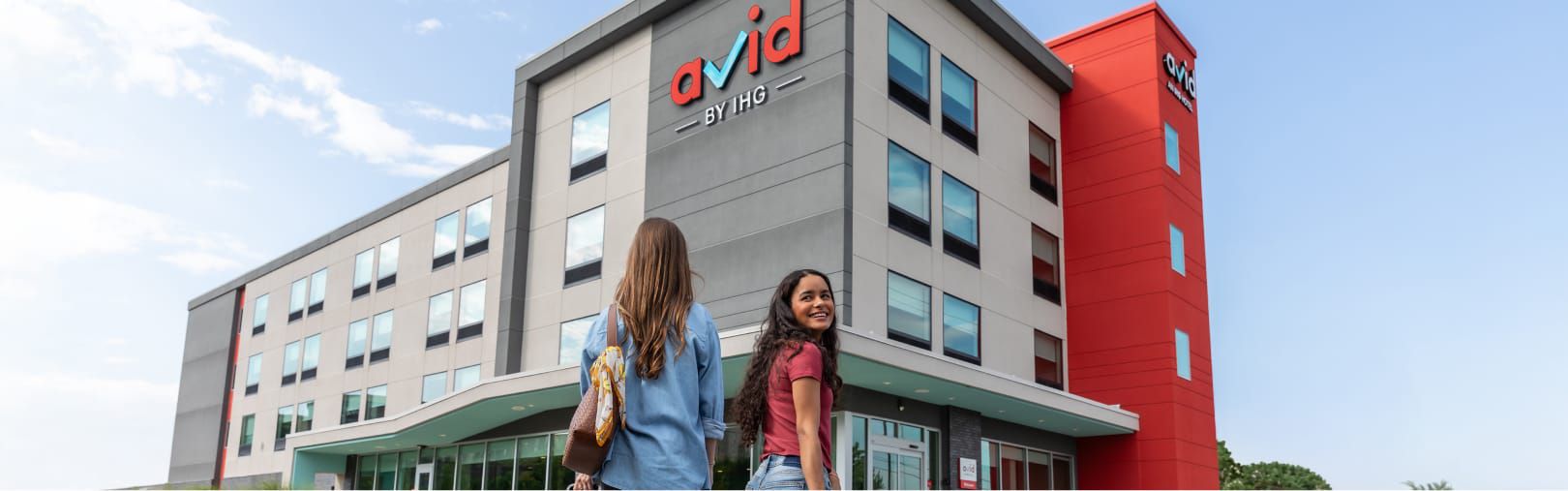 Dos mujeres entran en un hotel avid con las maletas