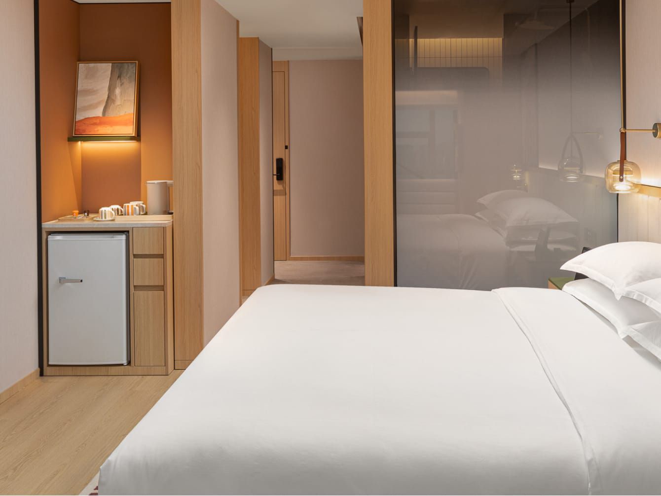 Modern hotel room with crisp bed and stocked minibar and fridge