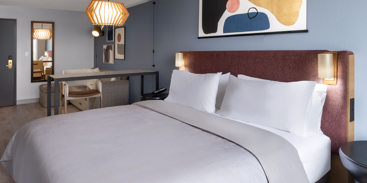 Quarto de hóspede com cama e espaço de trabalho no Atwell Suites Kansas City