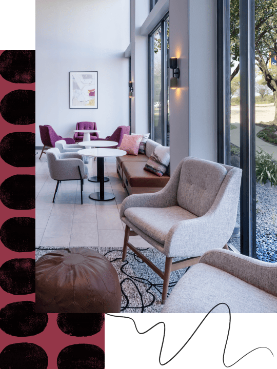 Sandalyeler, masa ve büyük pencereler bulunan modern salon alanı.