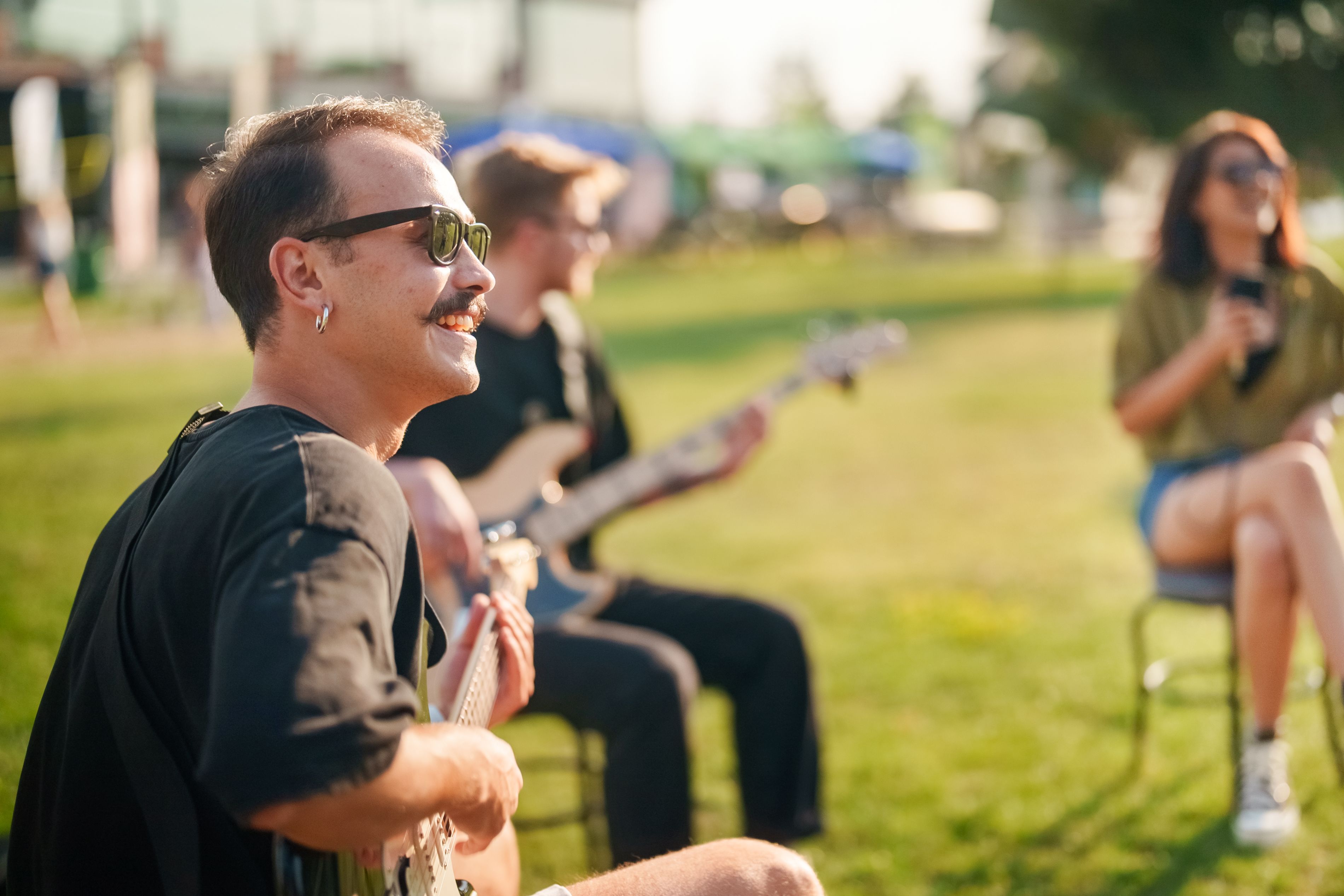 Band sitting and singing outside.