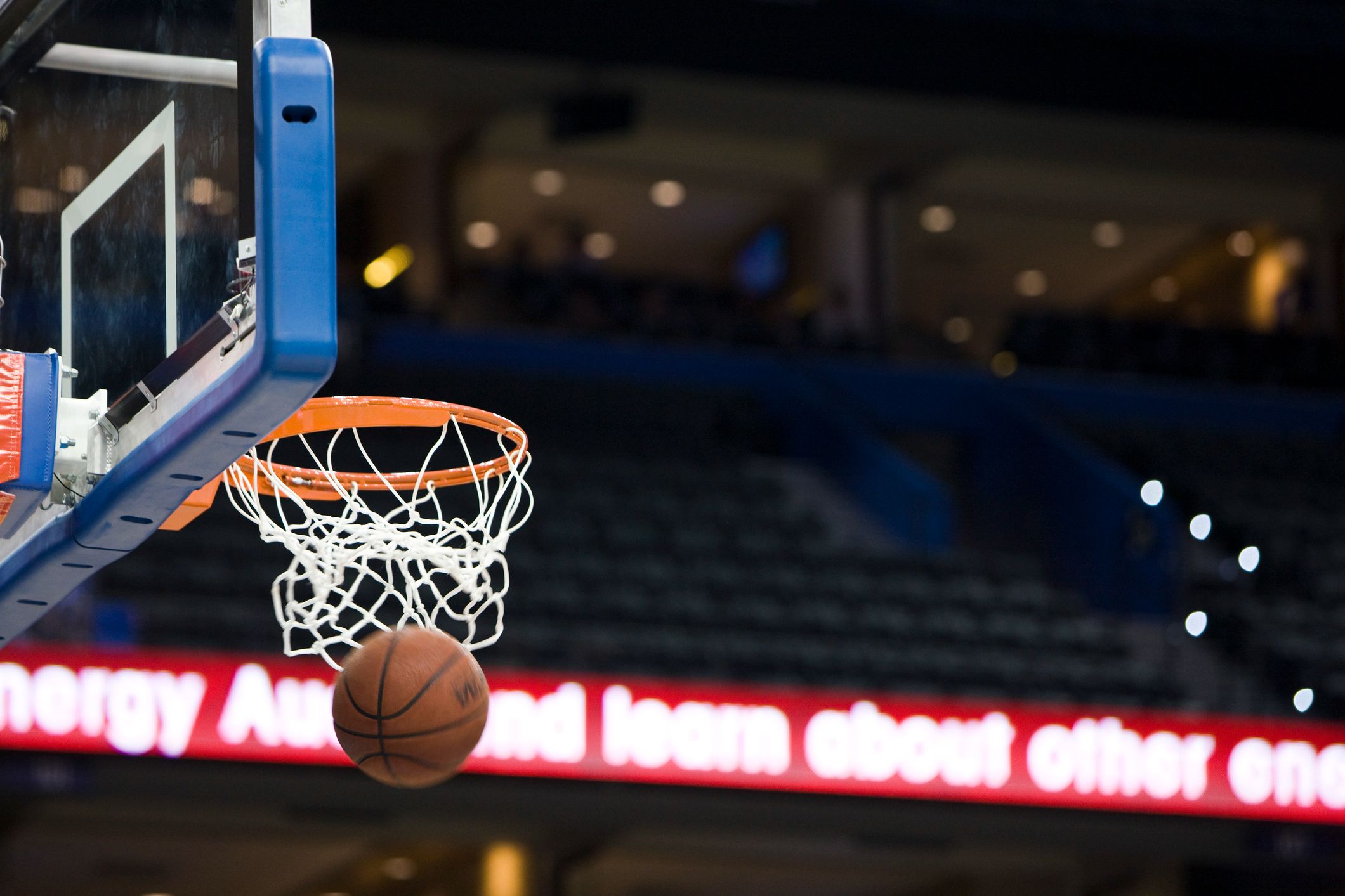 Basketball going into a hoop at an arena.