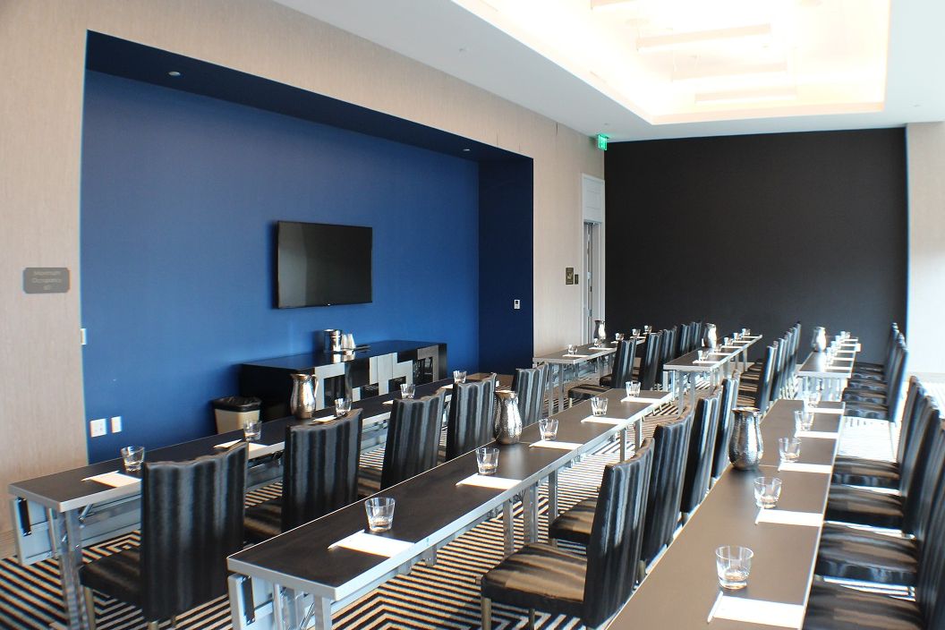 Belasco meeting room with long tables and TV on the center wall