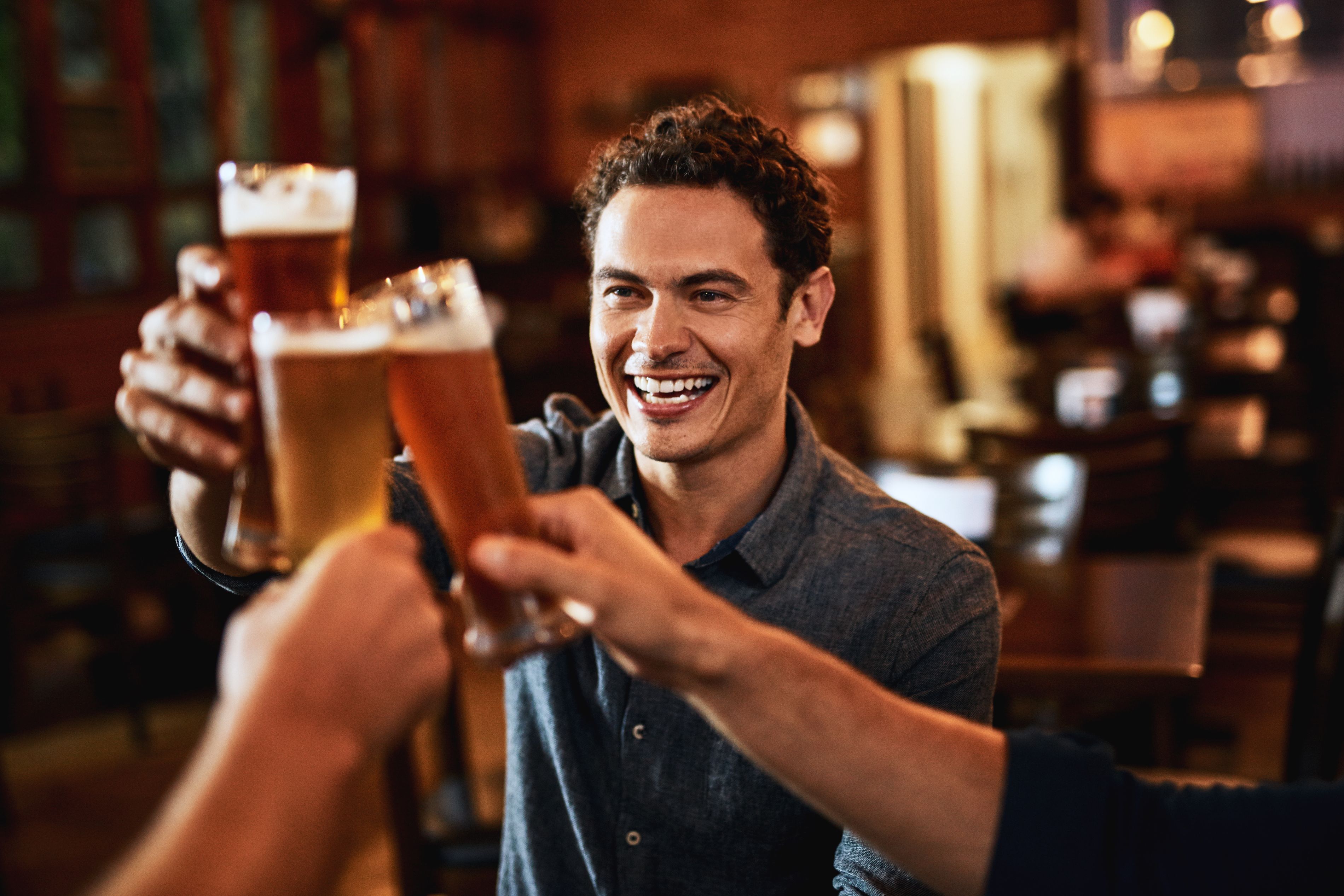 man with a beer cheersing with friend