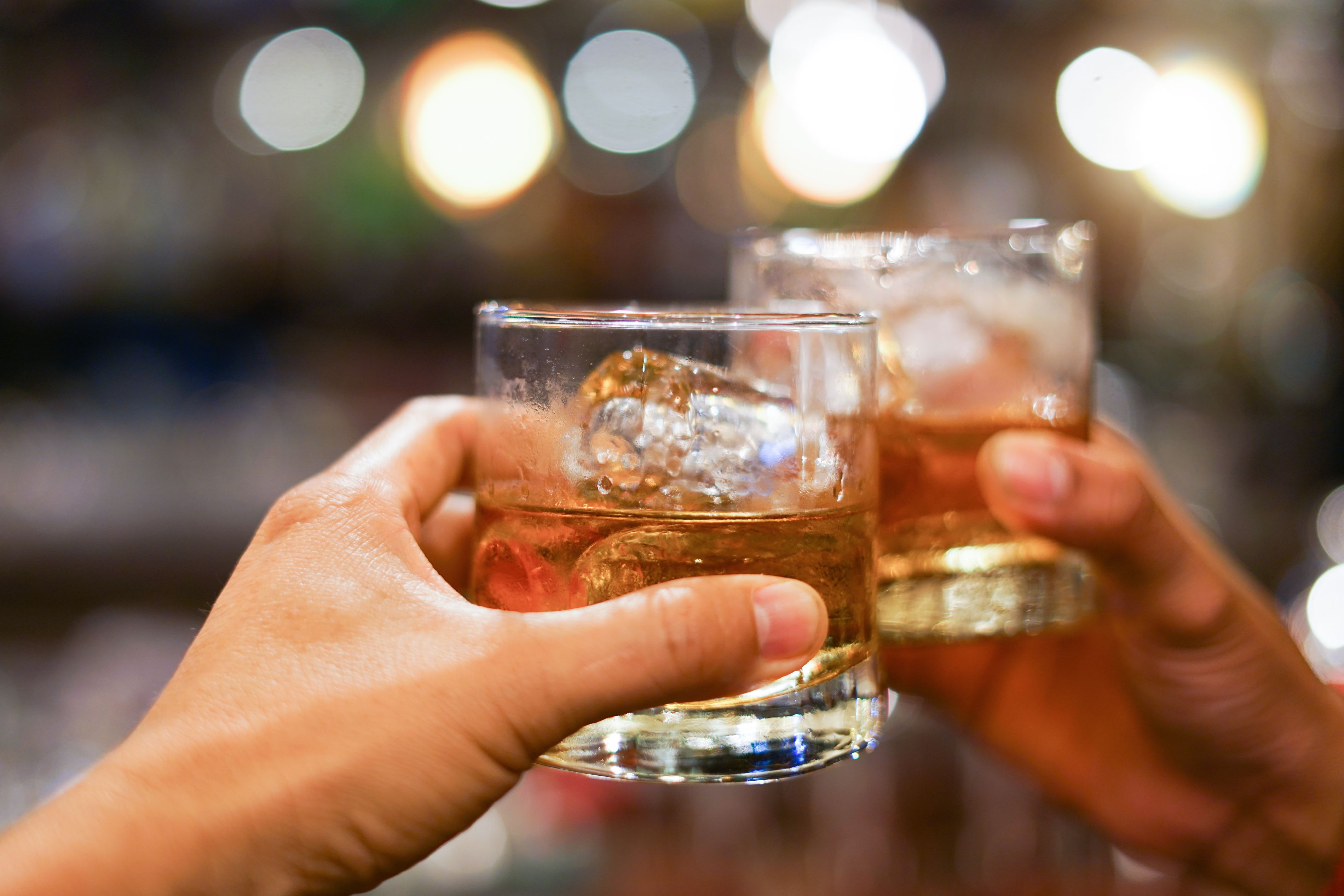 cheersing with whiskey glasses